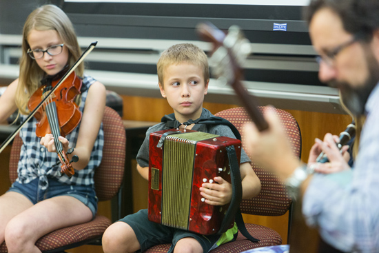 Irish musicians play music and poet reads poetry during and interdisciplinary class on the literature, politics, and culture of Irish Bostonians in the 19th and 20th century in the CGS building