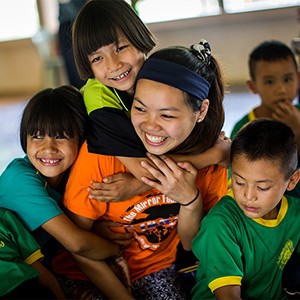 BU Sargent College student Grace Lei is hugged by children during a public health education trip to Ban Doi Chaang village in Thailand