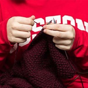 A student member of the BU Knitting Club, a Boston University club open to all students who crochet, weave, spin, or do embroidery