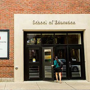 A student walks into the Boston University School of Education building