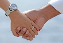 Detail photo of married couple holding hands