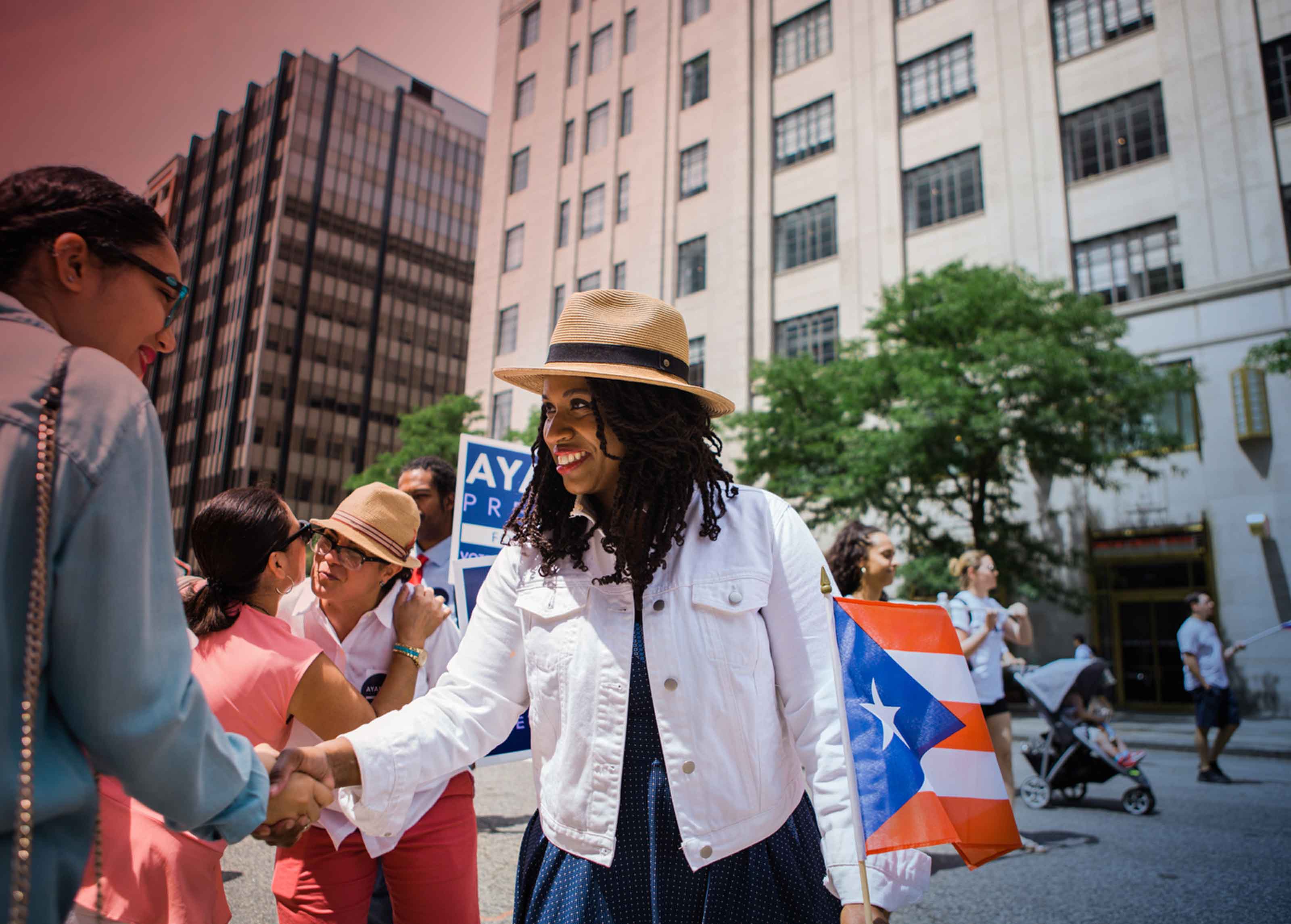 Ayanna Pressley, Massachusetts candidate for the House of Representatives, shakes a supporter's hand at the Boston Puerto Rican parade.