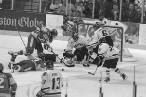 Ken McGowan (CAS’04) (upper left) and Mark Mullen (SHA’04) (lying on the ice) try to score in the Beanpot final. Photo by Vernon Doucette