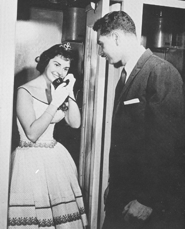 Belle in a Bell booth: In 1960, when this picture of a newly crowned homecoming queen calling home ran in the Hub yearbook, telephones in the United States numbered close to 81 million. The rotary dial was being challenged by TouchTone calling, which saw its first test-marketing. By 1969, the 90 millionth telephone had been installed, the Call-A-Matic telephone had been patented by Bell Laboratories, and the Bell System had adopted 911 as a nationwide emergency telephone number. A recent study reports that about 186 million new cell phone subscribers will sign up every year between now and 2007, bringing the global total to 2 billion. New and existing users will include a high number of BU students, who will follow the lead of Alexander Graham Bell, a BU professor of the mechanism of speech in the School of Oratory, and transmit their voices through time and space to connect with friends and family throughout the academic year.