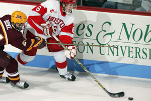 Minnesotas Michael Howe uses his stick to slow down forward Kenny Roche (CAS07). Photo by John Quackenboss.