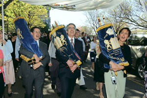 Carrying Torahs in a procession to the new Florence and Chafetz Hillel House May 12 are Avi Heller (UNI97), Bruce Ginsburg (CAS73), and Randi Kaplan, Orthodox, Conservative, and Reform rabbis, respectively. The Torahs were placed in the buildings three separate chapels. Photo by BU Photo Services