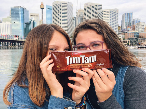 Two students holding up a picture of TimTam cookies