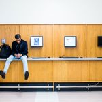 Student sitting on a counter next to a set of computers