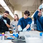 A group of four students doing an experiment in a lab