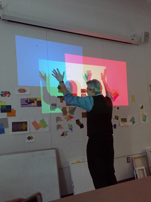 Professor Richard Raiselis shows students how mixing red, green, and blue light creates white.