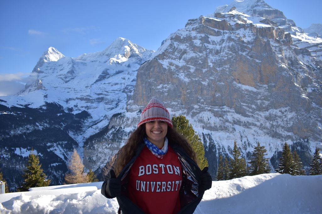 Emma Moneuse wearing a Boston University sweatshirt, with snow-capped mountains behind her