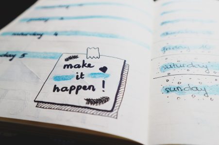 Closeup of a planner that says "make it happen!"