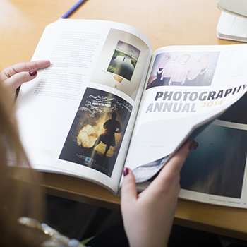 Student browsing design magazine.
