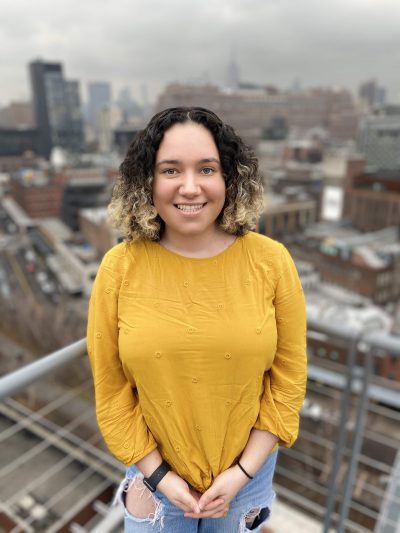 Cheyenne Darcy Amaya smiling in front of a cityscape.