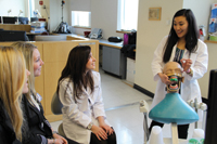 Luri Lee (right) and Daniella Rizzo (middle), both DMD 16, give a demonstration to two pre-dental students