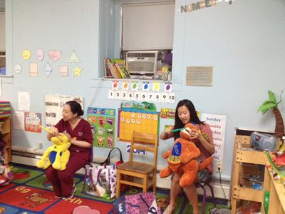 Margi Chan DMD 16 (left) and Ellen Yang demonstrate proper brushing techniques to preschoolers