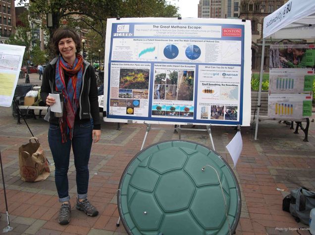 Margaret Hendrick, Great Methane Escape 10-16-13 Margaret Hendrick stands by an informational display highlighting research on methane escape in the city of Boston. Photo by Sayaka Yamaki