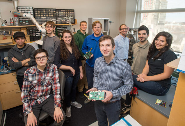 A BU group led by Brian Michael Walsh (ENG’10) (front, right) is developing a wireless network (or swarm) of minispacecraft, which contain magnetometers to measure the fine-scale structure of the Birkeland currents that create the Northern Lights. Photo by Cydney Scott