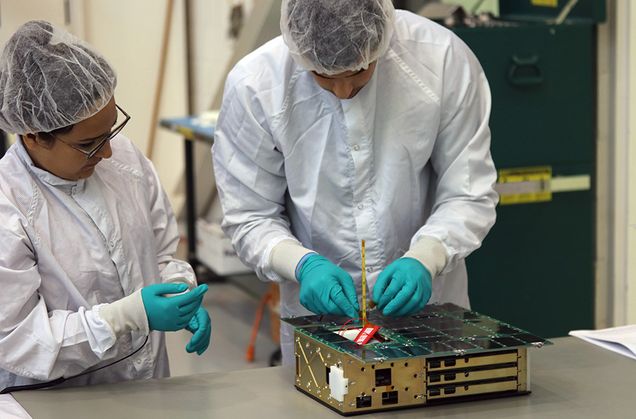 David Einhorn (ENG’17) (right) and Maria Kromis (ENG’17) inspect ANDESITE. Photo courtesy of Air Force Research Laboratory