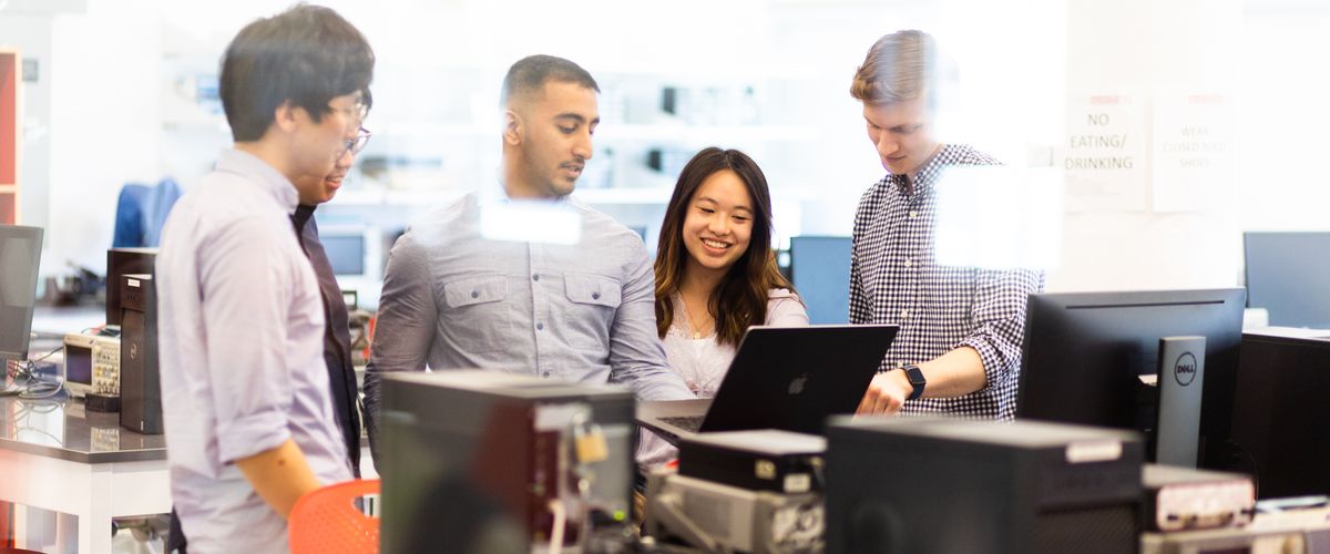 A group of students engaging with one another in a lab setting