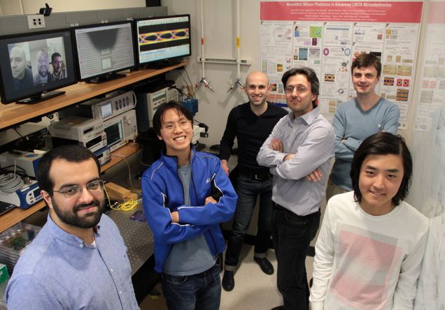 Boston University team in their laboratory joined by co-lead authors (left to right) Amir Atabaki, Fabio Pavanello and Sajjad Moazeni via video conference. Left to right in the photo: Kenaish Al Qubaisi, Imbert Wang, Hayk Gevorgyan, Assistant Professor Milos Popovic (ECE), Anatoly Khilo, and Bohan Zhang.(photo credit: Josep Fargas)