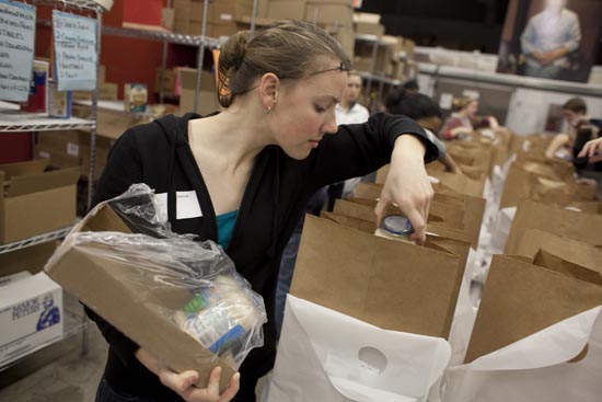 Boston University student Allison Thommaseau puts together packages of food at "Food and Friends" food bank in NE Washington. Photos by Dennis Drenner for Boston University