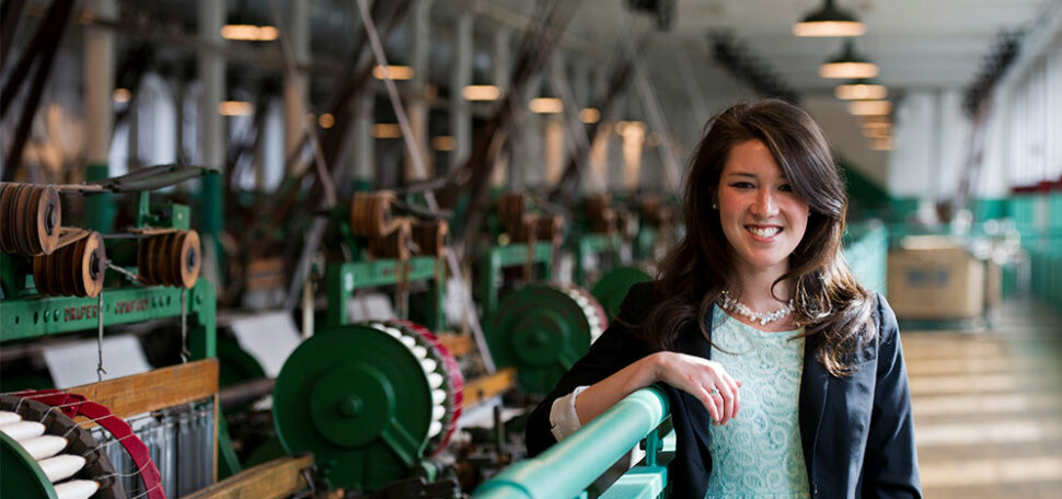 Chelsea Bray poses for a portrait with cotton milling machines in the historical Boott Cotton Mill in Lowell, MA said to be an inspiration for A Christmas Carol by Charles Dickens