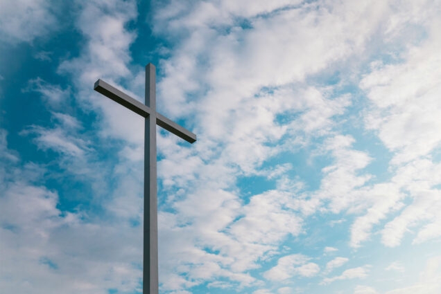 Photo: A cross in front of a blue sky background