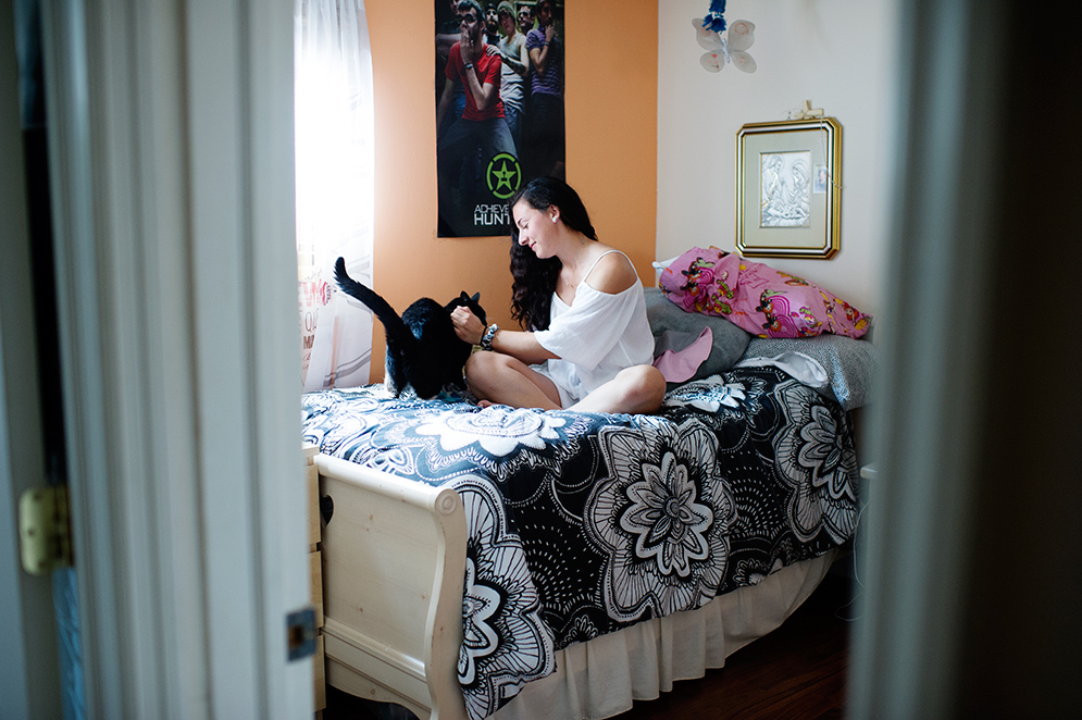 BU student Jessica Silva with her cat in her bedroom