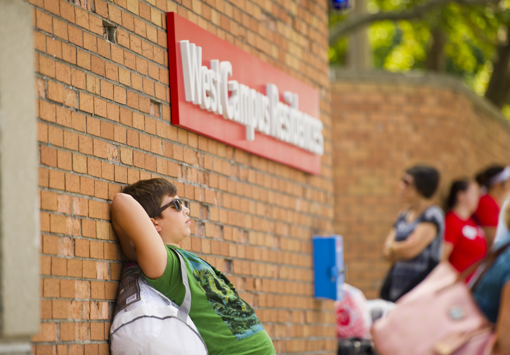 John Georgiopoulos, 12, of Greece, waits for his sister, Fleni Georgiopoulou (CGS'19) during West Campus move in August 25, 2015. Photo by Cydney Scott for Boston University Photography