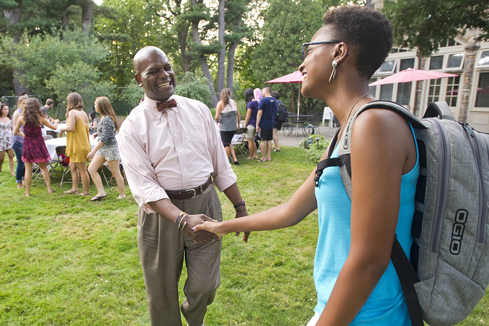 Dean of Student Kenneth Elmore, right, along with Michael Dennehy, Director of College Access, at left, greets Menino Scholars, including Alexxa Robinson (SHA'17) as they join them at Elmore's home for a welcome bbq Sept 2, 2015. Menino Scholars are Boston Public High School graduates who were awarded a four-year full-tuition merit scholarship to attend Boston University. Photo by Cydney Scott