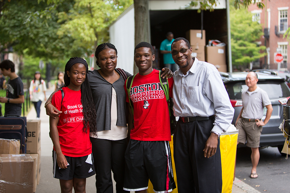 Itua Fughe Izogie (SAR 19), hugs his family as they move him into The Towers at BU. Photo by Mike Spencer