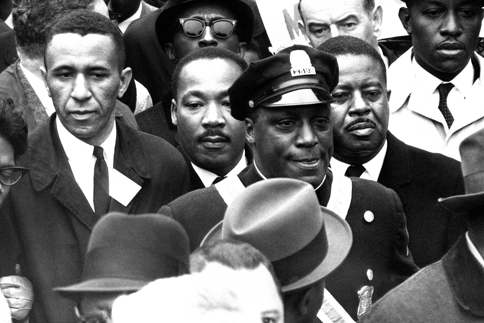 Dr. Martin Luther King Jr., is completely hemmed in as he and his aide Rev. Ralph Abernathy, right, lead march to historic Boston Common, April 23, 1965. King came to Boston to lead the demonstration to protest segregation in schools, jobs and housing. He will address a gathering at the Common. (AP Photo)