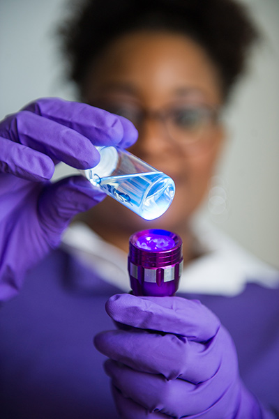 Malika Jeffries-EL of Boston University Department of Chemistry holds a vial of organic carbon polymer