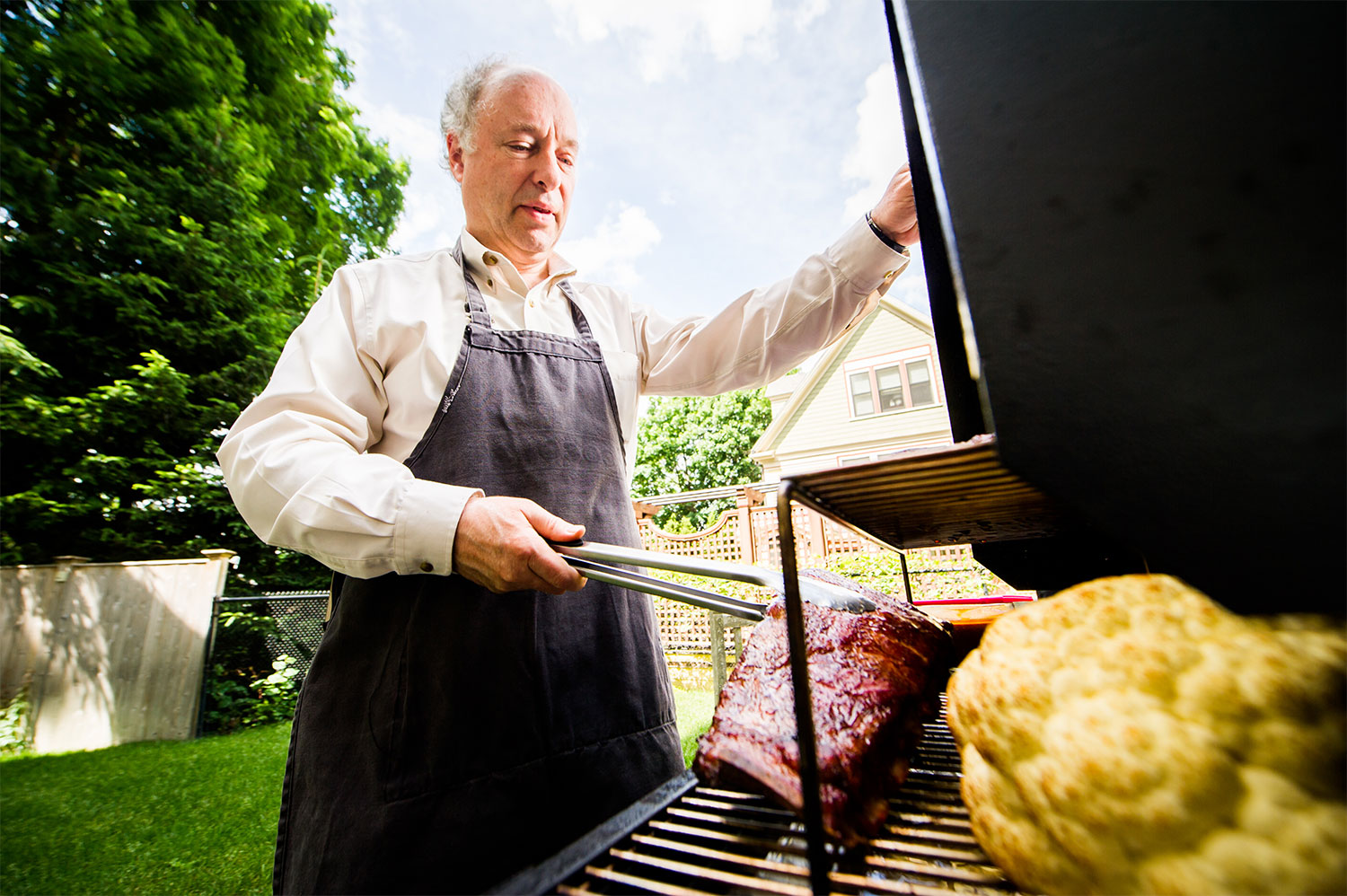 Greg Blonder, professor of engineering at Boston University, grills ribs and cauliflower on his backyard grill