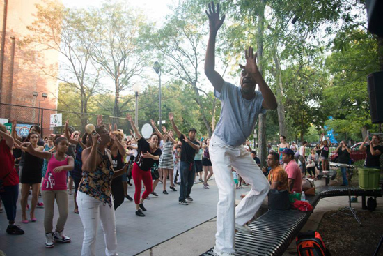A dance instructor leads a salsa dance class at the Salsa in the Park event at Blackstone Community Center Park in Boston