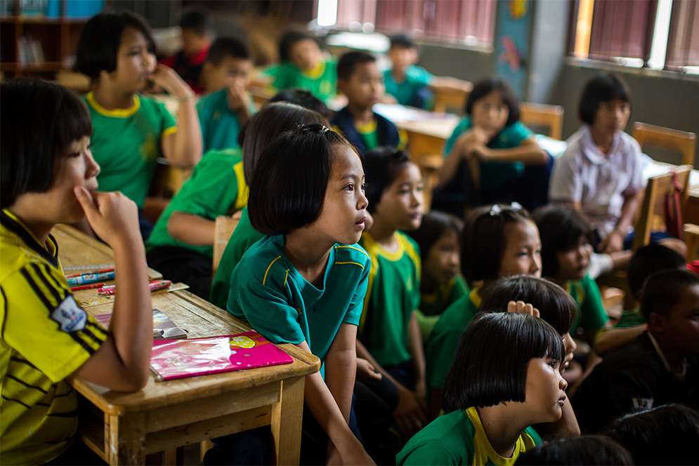 Thai schoolchildren listen to a class taught by BU Sargent College students and faculty during a public health education trip to Ban Doi Chaang village in Thailand