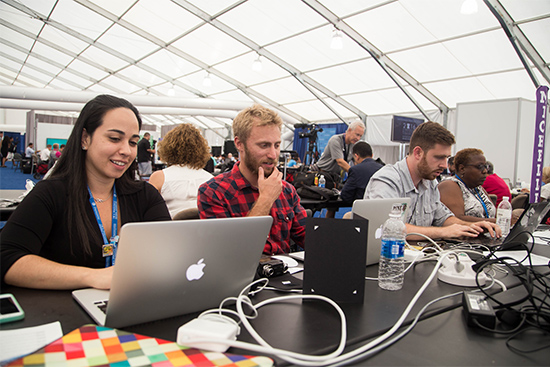 Boston University News Service students Andrea Asuaje (COM’17) (from left), Jonathan Gang (COM’17), Michael Sol Warren (COM’17), and Michelle Johnson, a COM associate professor of journalism, work inside the media tent outside the Wells Fargo Center during the 2016 Democratic National Convention. Photo by Pankaj Khadka (COM’16) for BUNS