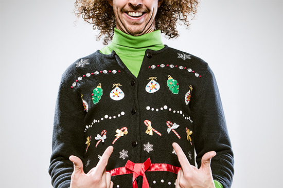 Man showing off ugly holiday sweater.