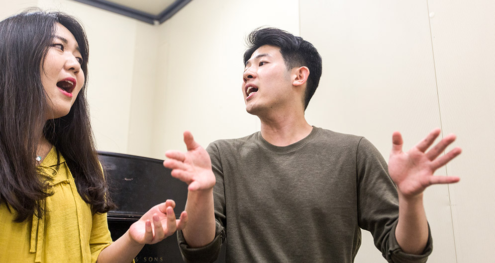 SuHyeon Lee (left) and Jay Lee rehearse a duet for the club’s spring concert, Sorian FM.