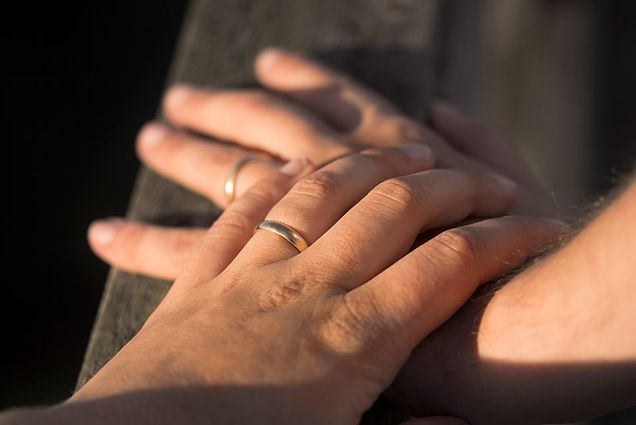 A married couple holds hands