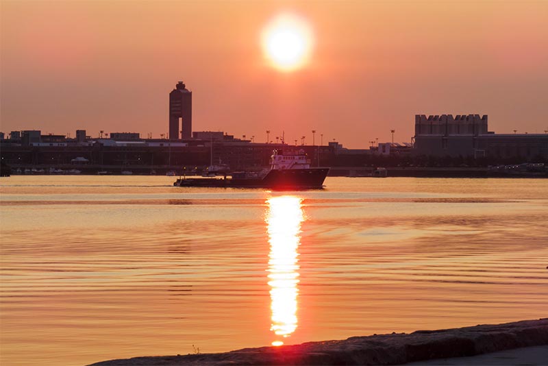 Summer sunrise over Boston Harbor with Logan International Airport in the background