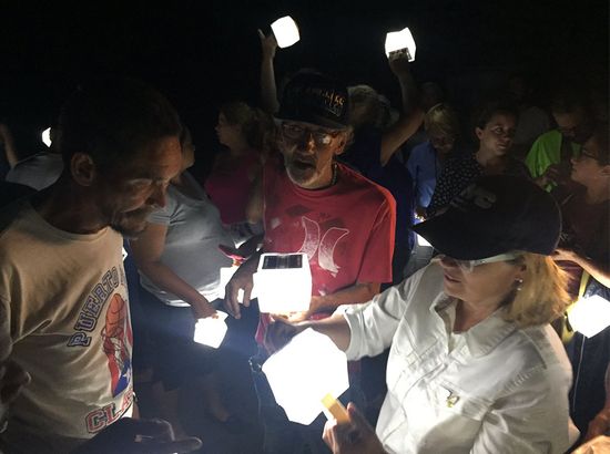 San Juan Mayor Carmen Yulin Cruz hands out solar lamps to residents of the La Perla community of San Juan Puerto Rico in the aftermath of Hurrican Maria.