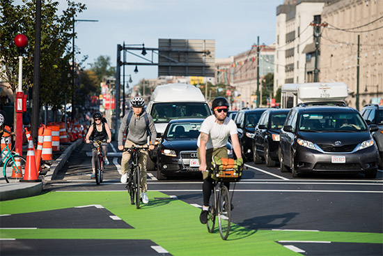 Cyclists ride in designated bike lanes on Commonwealth Avenue in Boston