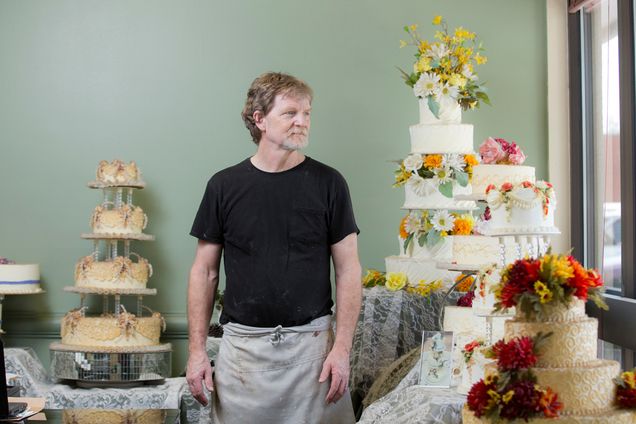 Jack Phillips, owner of Masterpiece Cakeshop, stands alongside display cakes.