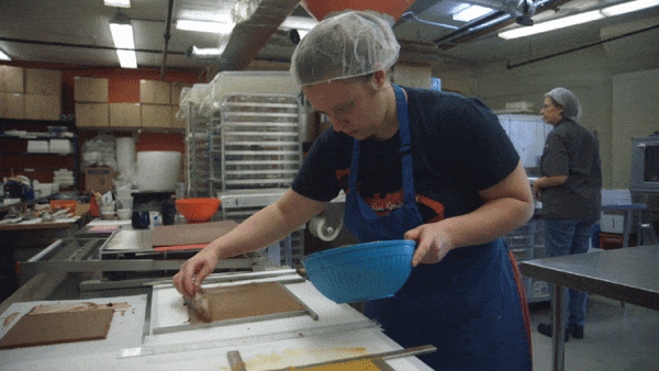 An EHChocolatier employee smooths sesame praline in the company's artisan chocolate kitchen