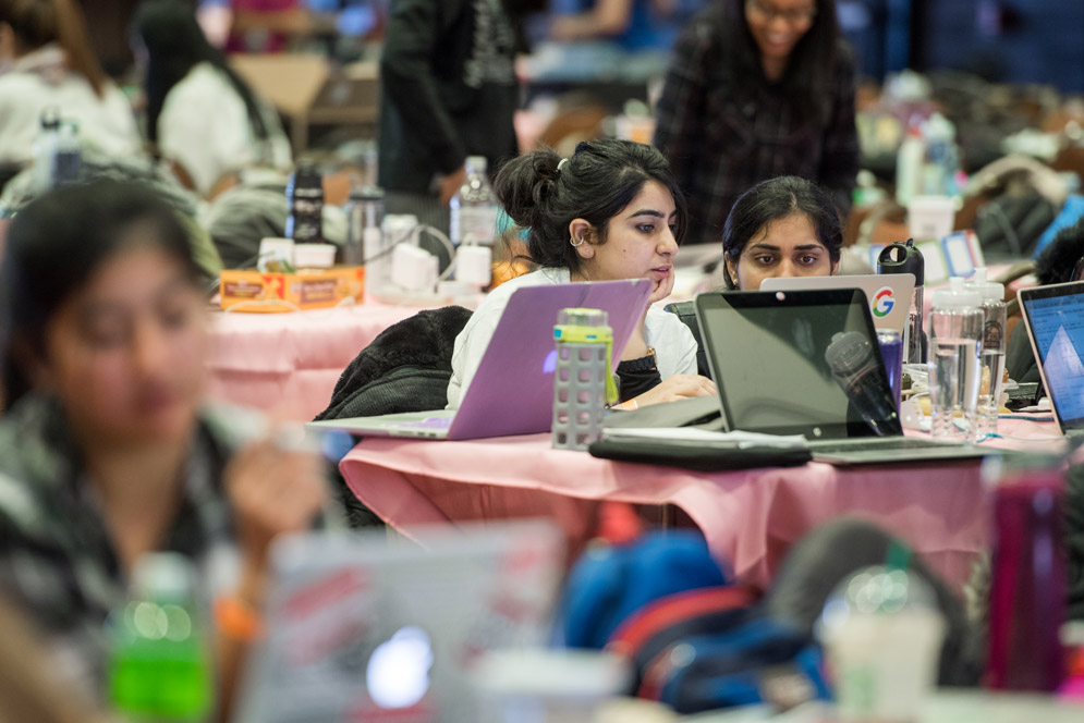 Two girls are shown working on work together on a Google Cloud Platform at SheHacks Boston