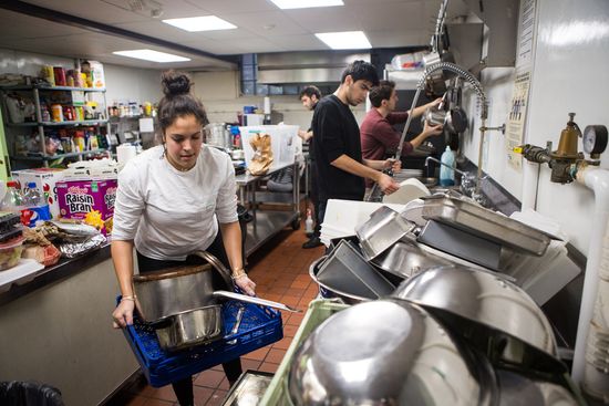 Mia Touma (CAS'21) puts away pots and pans at the Harvard Square Homeless Shelter.