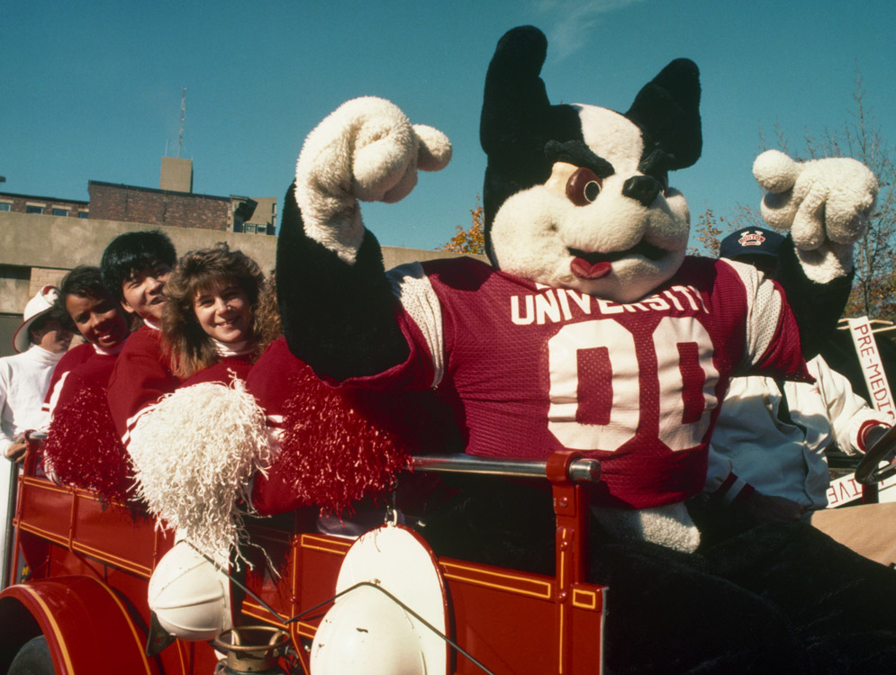 Rhett and BU cheerleaders ride to a game in a faux firetruck in 1989.