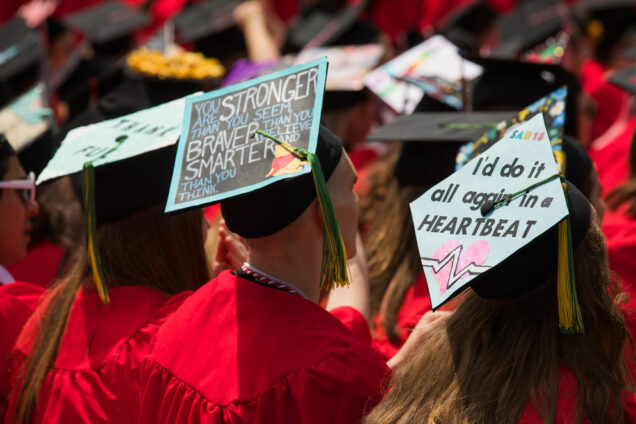Class of 2018 graduating students with decorated mortarboards at Boston University's 2018 Commencement